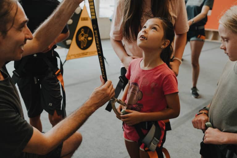 Children clip in and get ready to climb in the Gravity Lab at Climb So iLL.