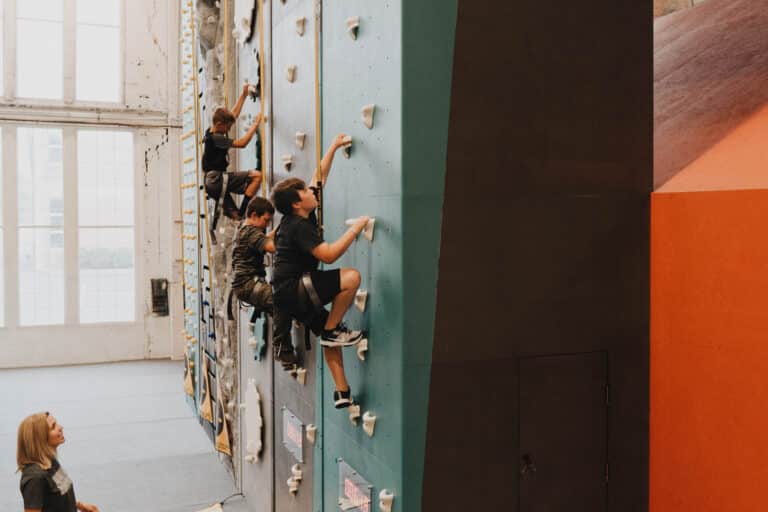 A group of kids climbs the walls in the Gravity Lab at Climb So iLL.