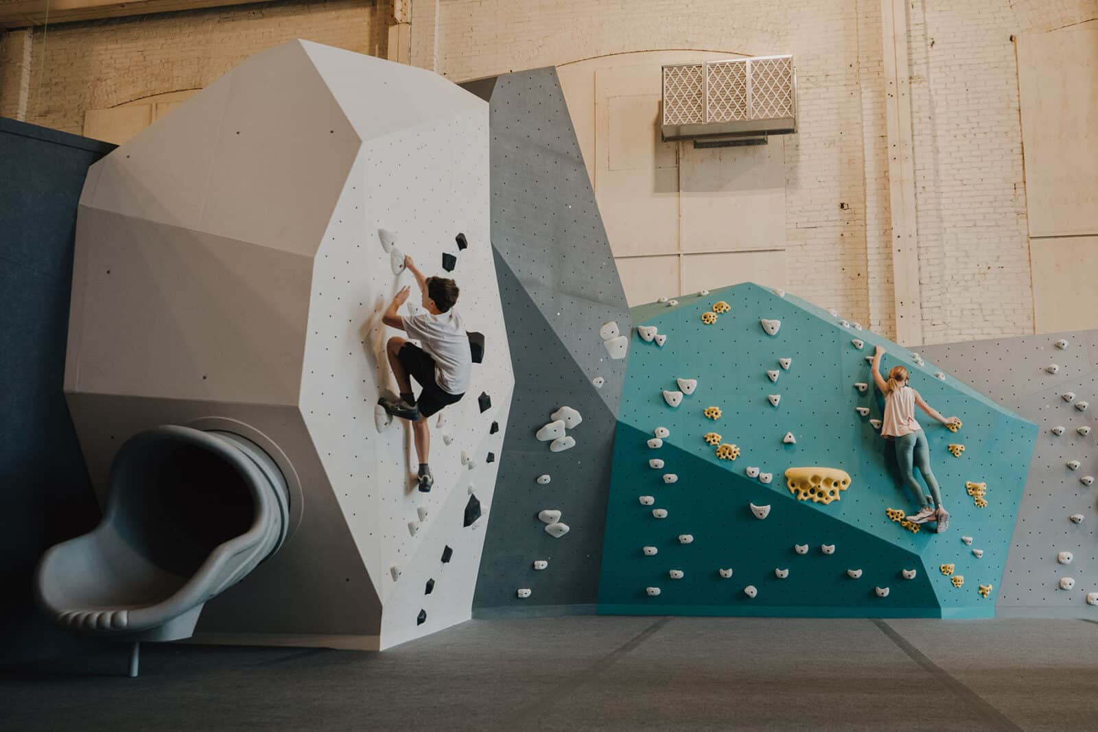 Two kids climb walls in the Gravity Lab in St. Charles.