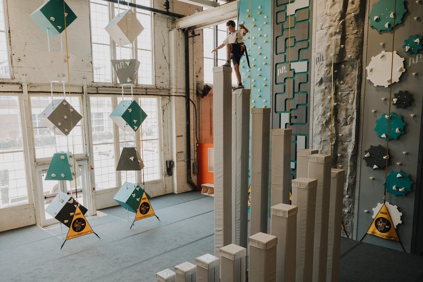 Boy balances on the towers in the Gravity Lab at Climb So iLL.